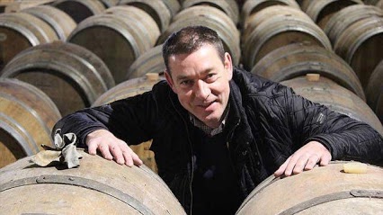 Stéphane Mordèles au cœur de la cave du Dragon Rouge à Dinard, entre les fûts de chêne